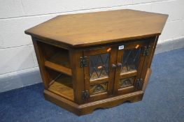 AN OAK OLD CHARM TV CABINET, double lead glazed doors enclosing a single shelf, width 103cm x