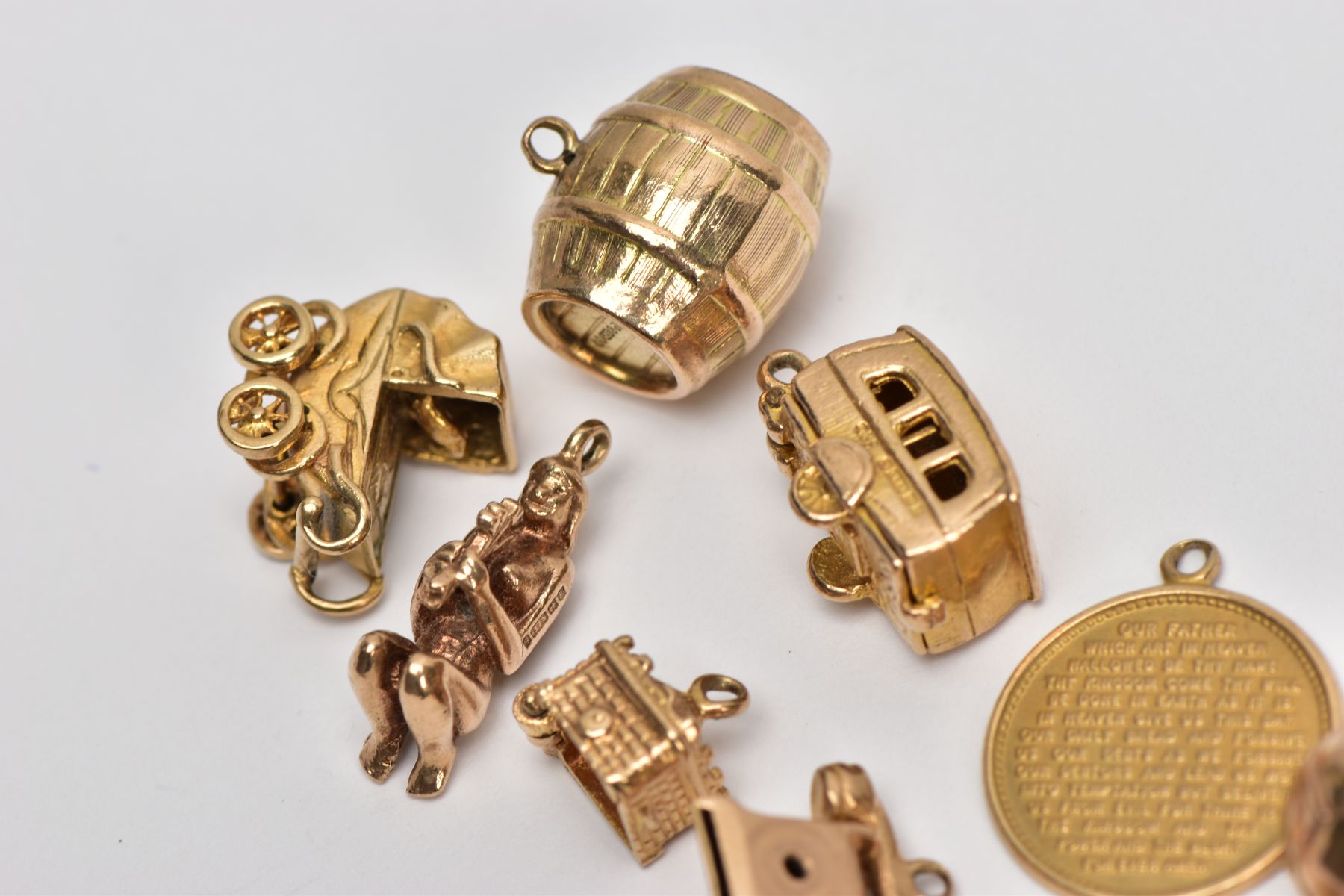 NINE 9CT GOLD CHARMS, to include a barrel, a hinged caravan, a pram and a telephone, all with 9ct - Image 2 of 3
