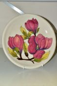 A MOORCROFT POTTERY PLATE, Magnolia pattern on cream ground, impressed marks to base and an adhesive