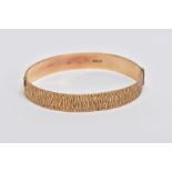 A 9CT GOLD HINGED BANGLE, bark texture to the full bangle, to the hidden hook style clasp, 9ct