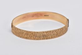 A 9CT GOLD HINGED BANGLE, bark texture to the full bangle, to the hidden hook style clasp, 9ct