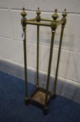 A BRASS UMBRELLA/STICK STAND with a cast iron base, 18cm squared x height 64cm