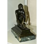 AFTER GIOVANNI BATTISTA FOGGINI, a bronze figure of a male scribe cast seated on a rock grinding a