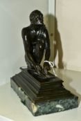 AFTER GIOVANNI BATTISTA FOGGINI, a bronze figure of a male scribe cast seated on a rock grinding a