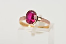A 22CT GOLD VICTORIAN DRESS RING, set with an oval cut synthetic ruby within a collet mount, plain