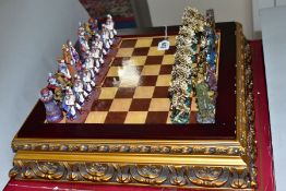 A BOXED MODERN CHESS SET, resin figures, modelled as fantasy figures, board mounted on a raised