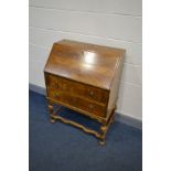 AN EARLY 20TH CENTURY WALNUT BUREAU, fall front door enclosing a fitted interior, above two