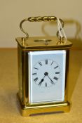 AN EARLY 20TH CENTURY FRENCH BRASS CARRIAGE CLOCK, the rectangular case with small oval panel to the