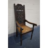 A 19TH CENTURY CARVED OAK WAINSCOT CHAIR, foliate carved back, solid seat and open armrests, width