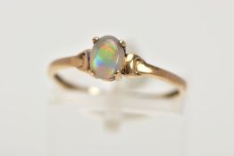 A YELLOW METAL OPAL RING, designed with a claw set, oval opal cabochon, plain polished band