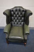 A GREEN LEATHER BUTTON BACK WINGBACK CHAIR on cabriole legs, width 90cm x depth 87cm x height