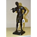 AFTER DEBUT, a bronze figure of a North African male water carrier, posed standing with a staff over