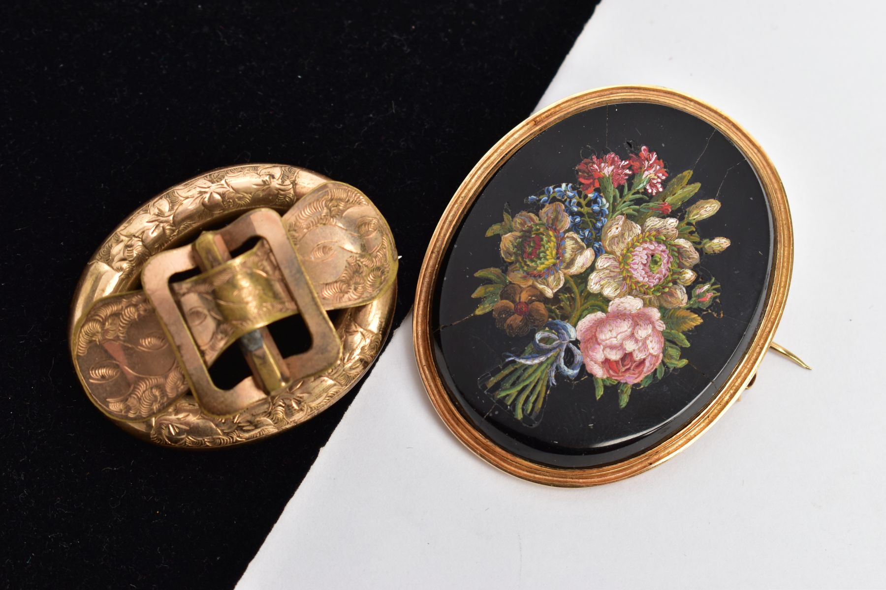 TWO VICTORIAN BROOCHES, to include a yellow metal hollow oval brooch with a foliate engraved belt