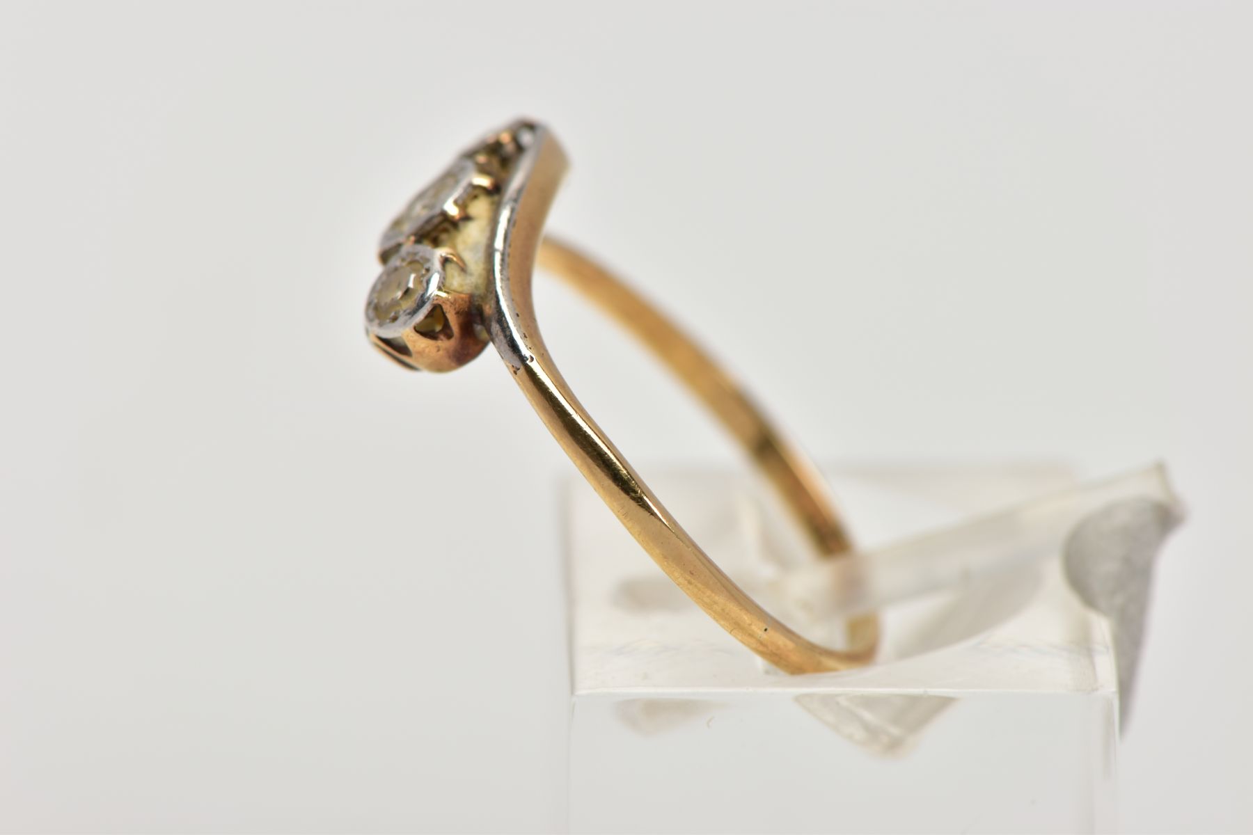 A YELLOW METAL, THREE STONE DIAMOND RING, of a crossover design, set with three illusion set round - Image 2 of 4