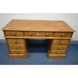 A PINE PEDESTAL DESK, with nine assorted drawers, width 138cm x depth 66cm x height 80cm