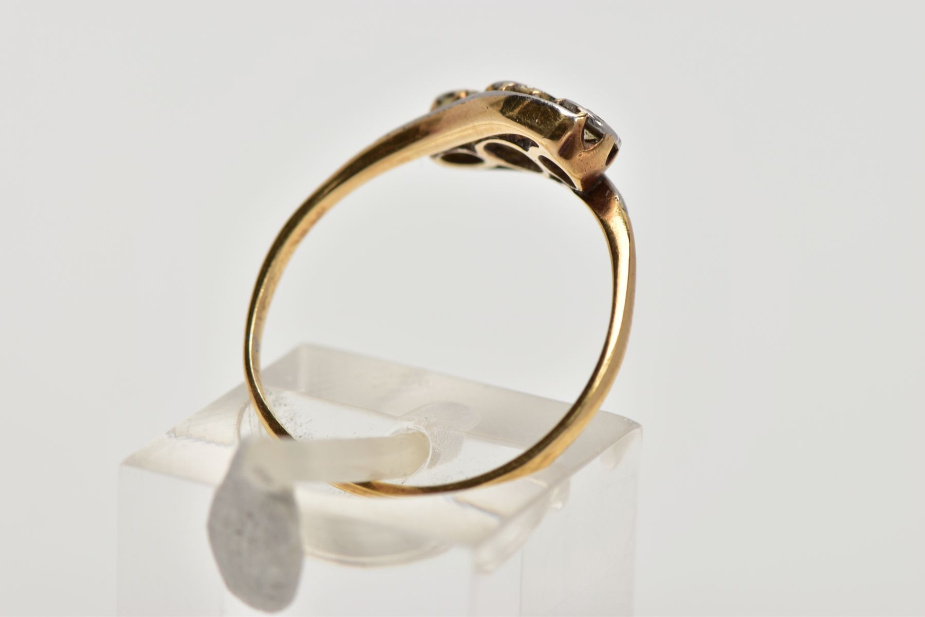 A YELLOW METAL, THREE STONE DIAMOND RING, of a crossover design, set with three illusion set round - Image 3 of 4