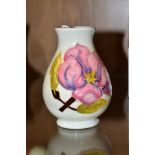 A SMALL MOORCROFT POTTERY VASE, magnolia pattern on cream ground, impressed backstamp, height 9.