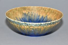 RUSKIN POTTERY, a footed bowl covered in orange, green and blue glazes, impressed Ruskin England