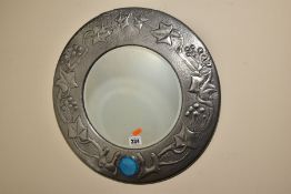 AN ARTS & CRAFTS STYLE CIRCULAR PEWTER FRAMED MIRROR, inset with bevel edged glass to the centre and