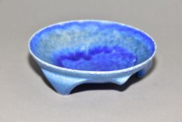 RUSKIN POTTERY, a shallow bowl raised on three feet, blue crystalline glaze, impressed Ruskin