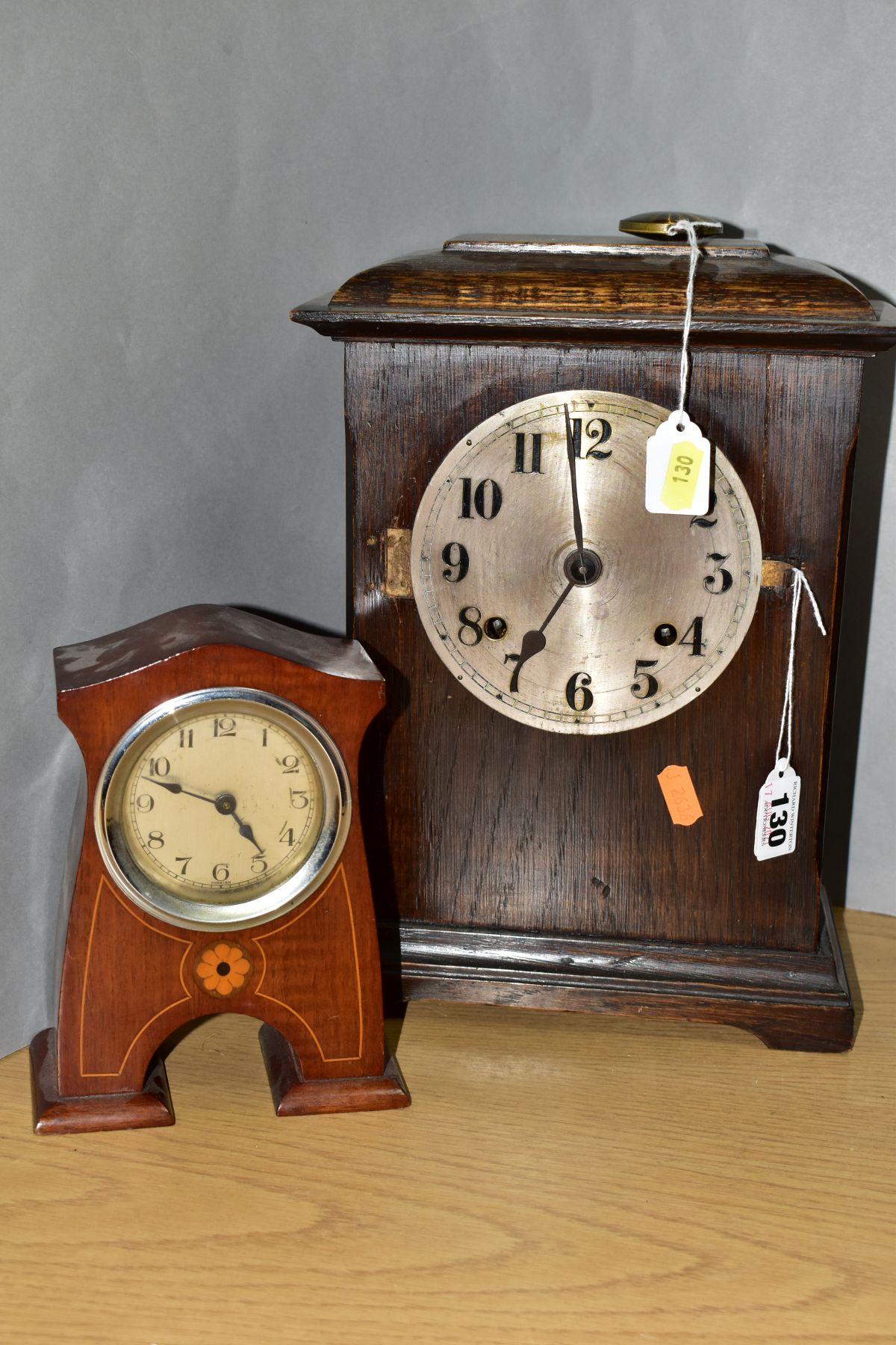 AN EARLY 20TH CENTURY OAK CASED MANTEL CLOCK, the caddy style top above a silvered dial with