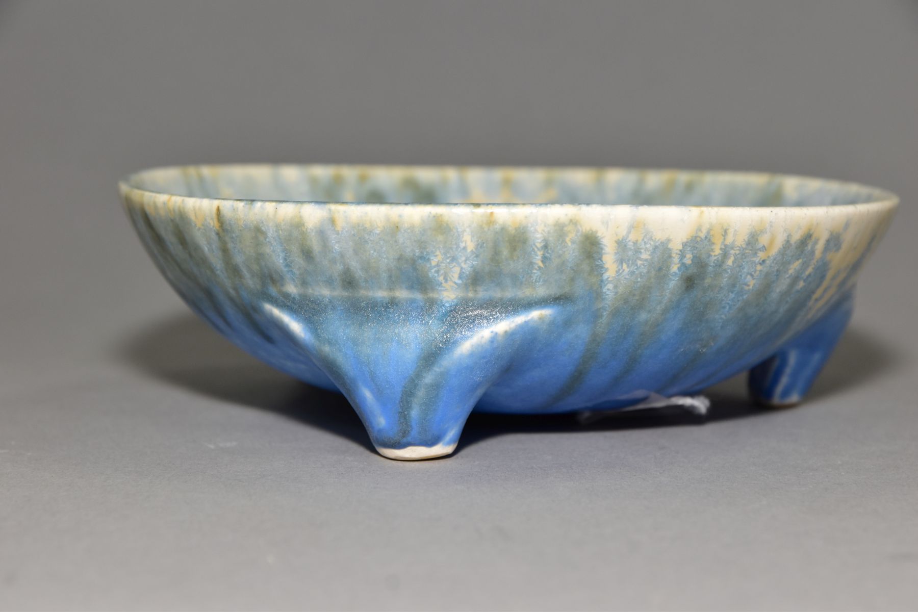 RUSKIN POTTERY, a shallow bowl raised on three feet, blue and orange crystalline glaze over white - Image 2 of 4