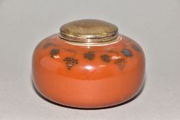 RUSKIN POTTERY, a storage jar of compressed oval form with metal collar and lid, brown high gloss