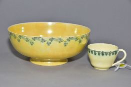 RUSKIN POTTERY, a footed eggshell bowl, covered in a yellow glaze with a band of clover to the outer