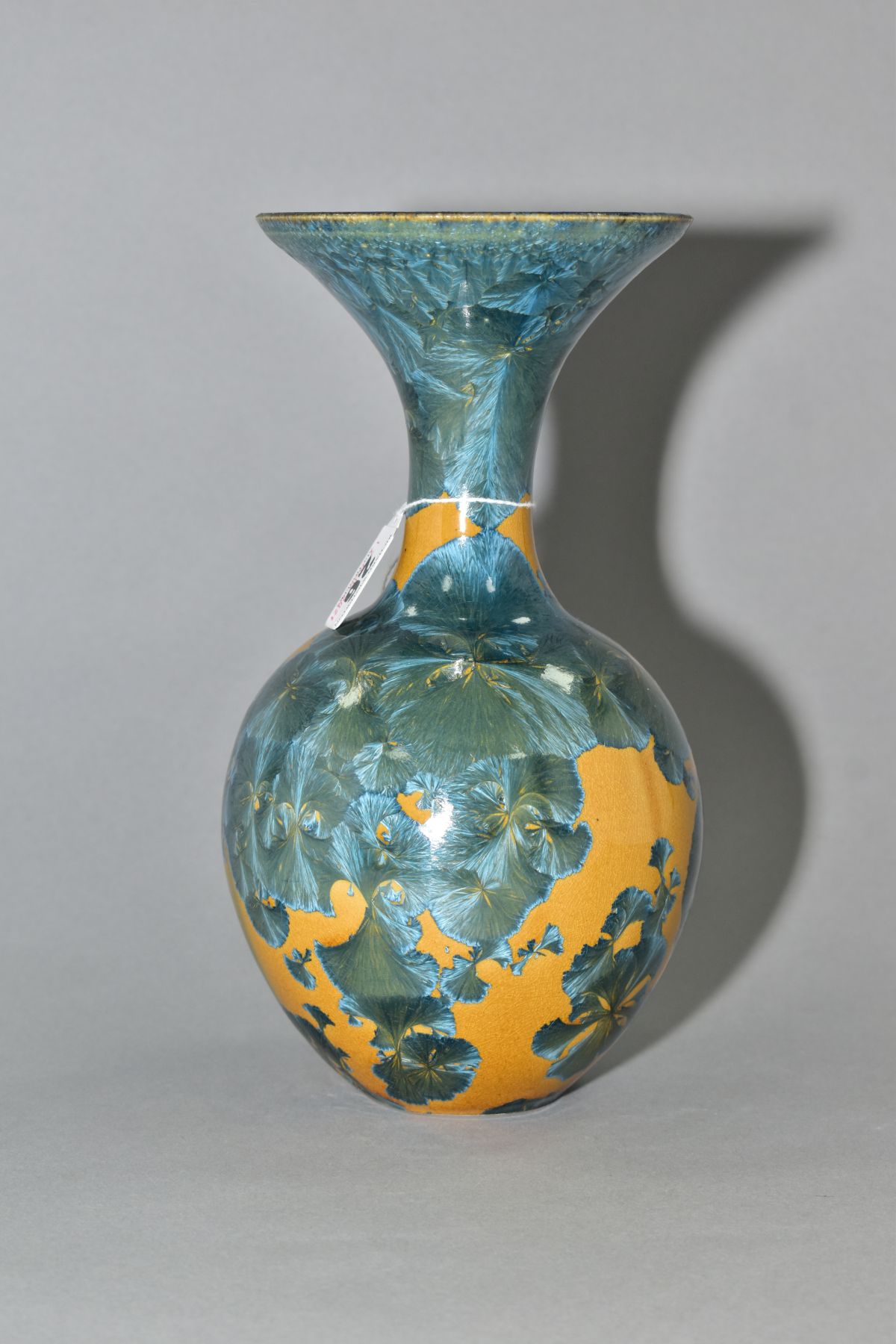 A SIMON RICH (BORN 1949) STUDIO POTTERY CRYSTALLINE GLAZED BOTTLE VASE, wide flared rim, ochre