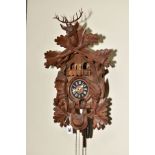 A SECOND HALF 20TH CENTURY WOODEN CUCKOO CLOCK, the case carved with gabled roof, Stag's head, hare,