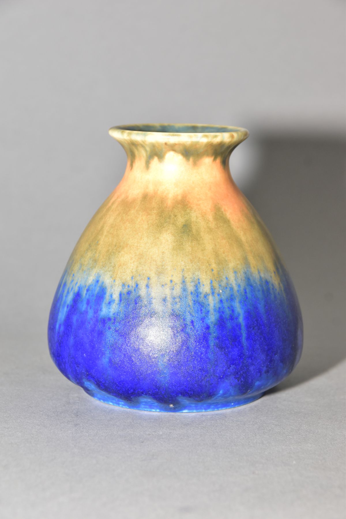RUSKIN POTTERY, a conical vase with flared rim, bands of orange, green and blue glaze, approximate