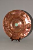 AN ARTS AND CRAFTS STYLE COPPER CHARGER, embossed with a band of foliate motifs, the central