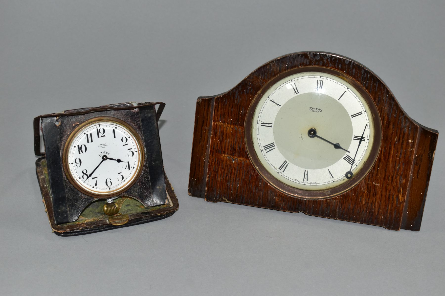 AN EARLY 20TH CENTURY ASPREY 8 DAY TRAVEL CLOCK, in a damaged leather folding case, incomplete,