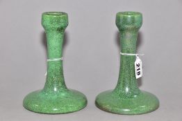 RUSKIN POTTERY, a pair of candlesticks covered in green tea dust glaze, inscribed Ruskin England