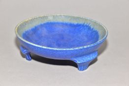 RUSKIN POTTERY a bowl raised on three feet, blue crystalline glaze to the inside surface,