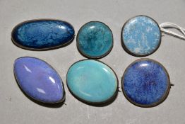 FIVE RUSKIN ENAMEL BROOCHES AND A RUSKIN STYLE BROOCH, comprising a circular Ruskin enamel mounted