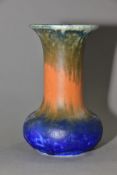 RUSKIN POTTERY, an onion shaped vase covered in bands of green, orange and blue glaze, impressed