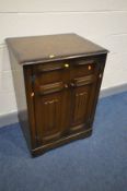 A REPRODUCTION WALNUT MEDIA CABINET, with a fold over lid enclosing a pull out slide, width 96cm x