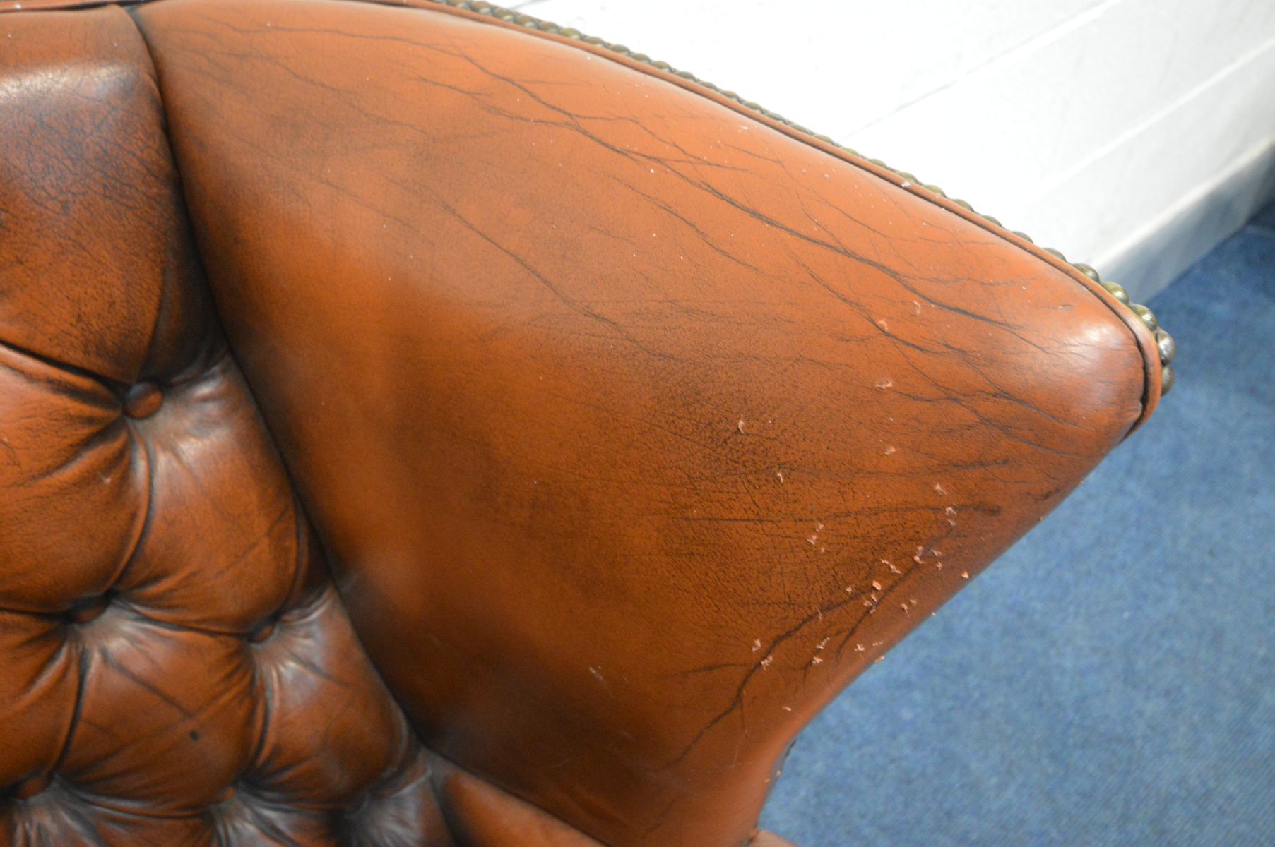 A BURNT ORANGE LEATHER BUTTON WINGBACK ARMCHAIR (condition - rip to left arm, crack to right arm, - Image 2 of 5