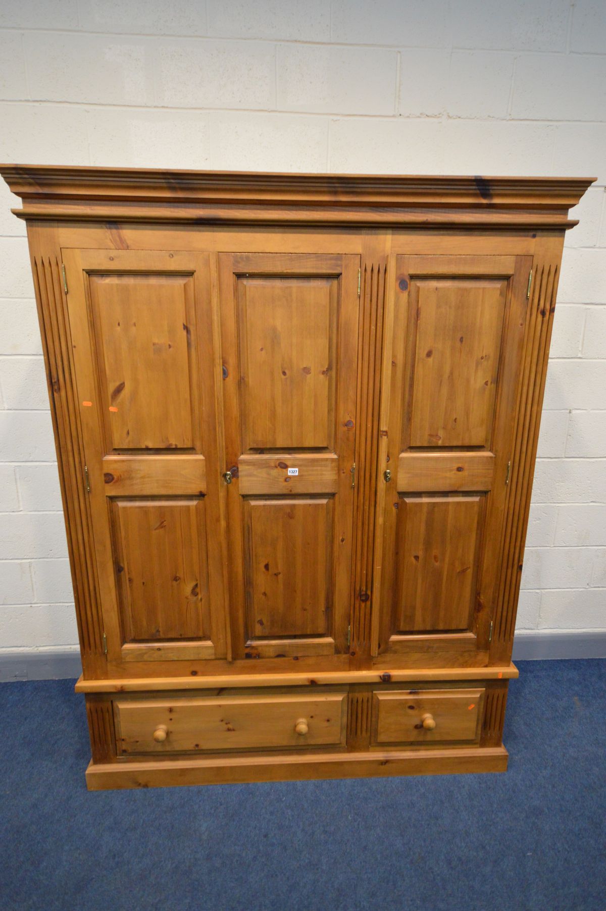 A PINE PANELLED THREE DOOR WARDROBE, with two drawers, width 161cm x 63cm x height 204cm (two keys)