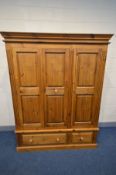 A PINE PANELLED THREE DOOR WARDROBE, with two drawers, width 161cm x 63cm x height 204cm (two keys)