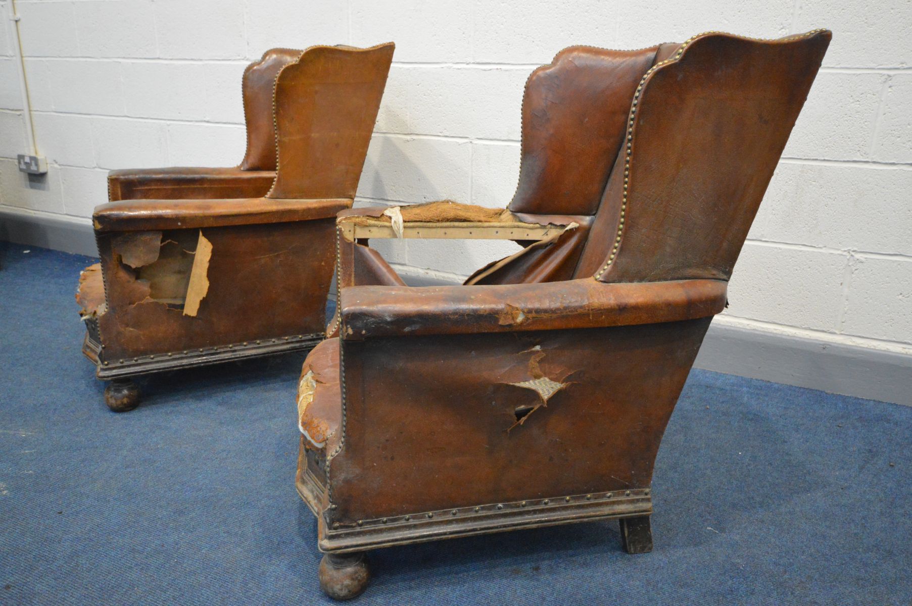 A PAIR OF DISTRESSED EARLY 20TH CENTURY BROWN LEATHER WINGBACK CLUB CHAIRS, on front bun feet, width - Image 7 of 7
