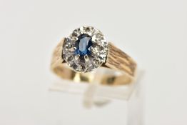 A 9CT GOLD SAPPHIRE AND DIAMOND CLUSTER RING, slightly raised cluster set with an oval cut blue