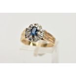 A 9CT GOLD SAPPHIRE AND DIAMOND CLUSTER RING, slightly raised cluster set with an oval cut blue