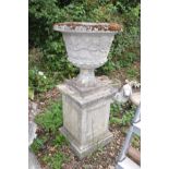 A COMPOSITE GARDEN URN ON A SQUARE COLUMN BASE with two section top showing foliate detailing and