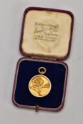 A YELLOW METAL FOB MEDAL, decorated with an embossed flower to the front, engraved to the reverse '