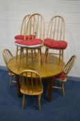 A PINE CIRCULAR DINING TABLE, diameter 123cm x height 74cm and six Ercol style quacker back