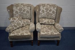 A PAIR OF BEIGE AND FLORAL UPHOLSTERED WING BACK ARMCHAIRS on a mahogany frame (no fire labels but