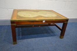 A MAHOGANY AND BRASS BANDED COFFEE TABLE, depicting a world map in two globes, with a glass top