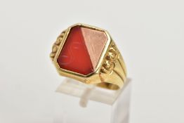 A GENT'S YELLOW METAL CARNELIAN SIGNET RING, rectangular shape with cut off corners, half set with a